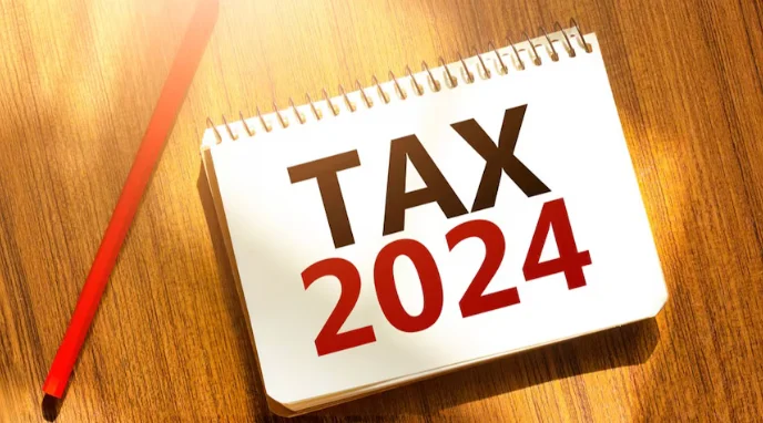 Tax 2024 written on a notepad, represents financial planning & record-keeping for the consecutive year
