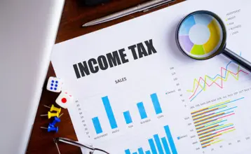 A Person analysing the document with magnifier shows income tax returns for the consecutive year