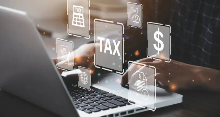 A laptop user performs a tax audit by examining financial data and timely filing taxes with global connections.